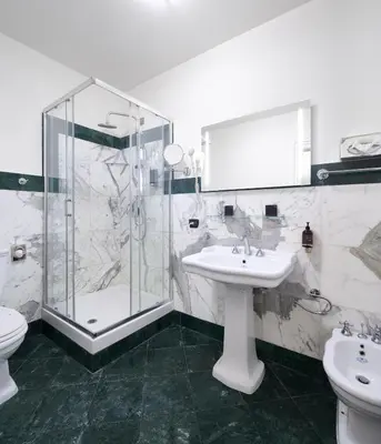 a bathroom with a shower and a sink and a toilet at Hotel Leon D´Oro in Prague