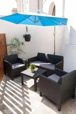 a patio with two couches and a blue umbrella at Residence Vysta in Prague