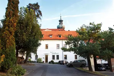 a large white building with a red roof at Hotel Adalbert in Prague