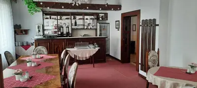 a dining room with two tables and a kitchen at Hotel Excellent in Prague