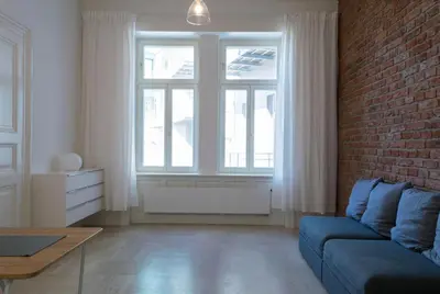 a living room with a blue couch and a brick wall at Stay in heart of town in Prague