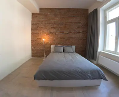 a bedroom with a bed and a brick wall at Stay in heart of town in Prague