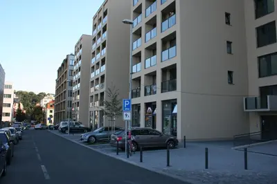 a city street with cars parked next to a building at Karlín Apartment in Prague