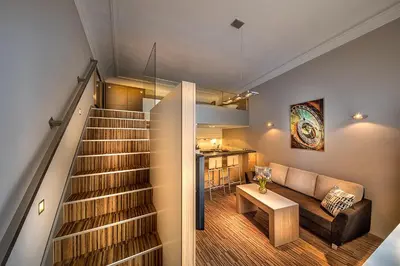 a staircase in a living room with a couch and a table at Stylish apartment in old town Prague in Prague