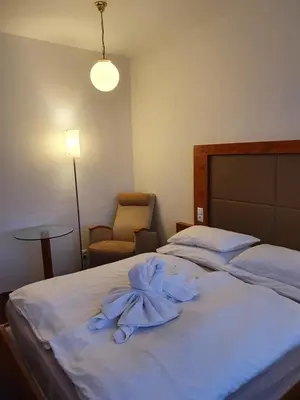 a hotel room with two beds and a chair at Hotel Jerabek in Prague