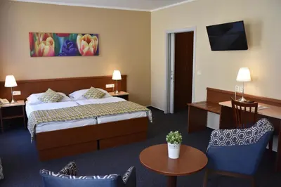 a hotel room with a bed and a table and chairs at Aparthotel Austria Suites in Prague