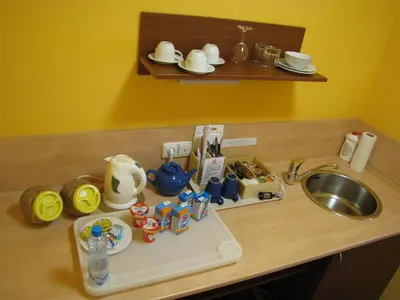 a kitchen counter with a sink and a tray with utensils at Aparthotel Austria Suites in Prague