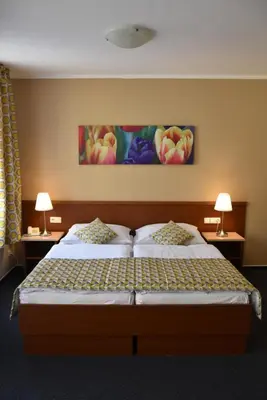 a bedroom with a large bed with two lamps at Aparthotel Austria Suites in Prague