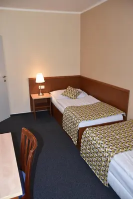 a hotel room with two beds and a table with a lamp at Aparthotel Austria Suites in Prague
