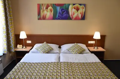 a bedroom with a bed with two tables and two lamps at Aparthotel Austria Suites in Prague