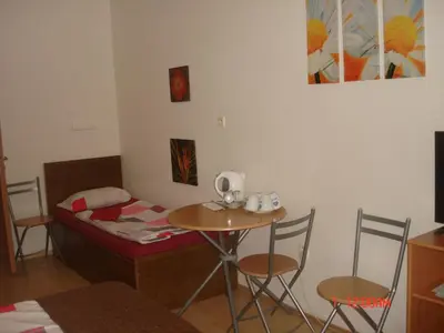 a room with a small table and a bed with chairs at Pension Easy Journey in Prague