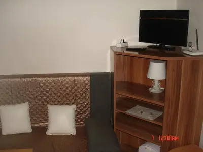 a room with a tv and a couch with two pillows at Pension Easy Journey in Prague