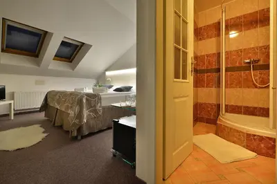 a bedroom with a bed and a bathroom with a tub at Anette Hotel in Prague