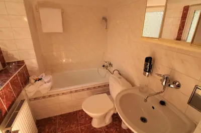 a bathroom with a toilet and a sink and a tub at Anette Hotel in Prague
