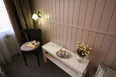 a room with a table and a chair and a table with flowers at Anette Hotel in Prague