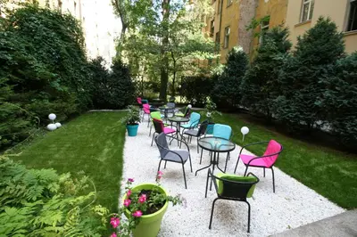 a group of tables and chairs in a garden at Anette Hotel in Prague