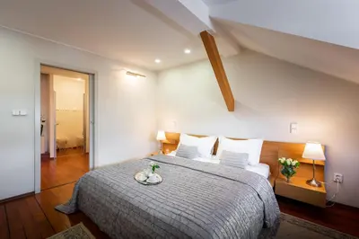 a bedroom with a large bed with a wooden floor at Apartments Almandine in Prague