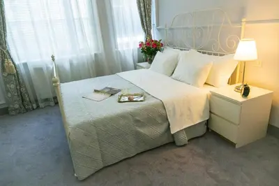 a bedroom with a bed and a lamp and flowers at Apartments Almandine in Prague