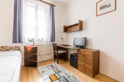 a room with a desk with a computer and a bed at Pension Dientzenhofer in Prague
