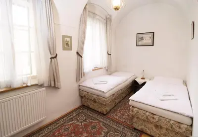 two twin beds in a room with a window at Pension Dientzenhofer in Prague