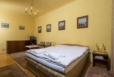 a bedroom with a bed and a table and chairs at Pension Dientzenhofer in Prague