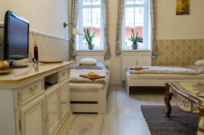 a room with two beds and a tv and two windows at Studio near Congress Centre II. in Prague