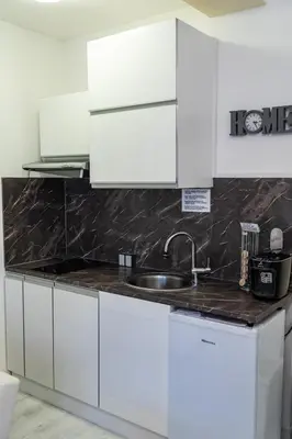 a kitchen with white cabinets and a sink at Studio near Congress Centre II. in Prague