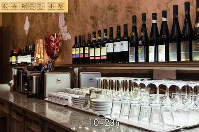 a counter with wine glasses and bottles of wine at Hotel Karlštejn & SPA in Karlštejn