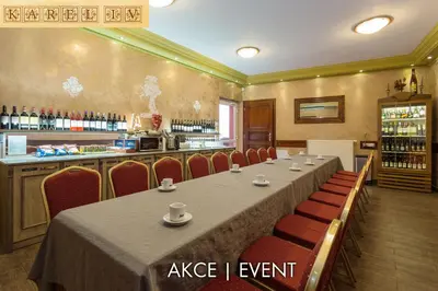 a conference room with a table and chairs and a bar at Hotel Karlštejn & SPA in Karlštejn