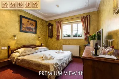 a bedroom with a bed and a desk and a window at Hotel Karlštejn & SPA in Karlštejn