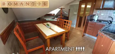 a kitchen with a wooden table and some chairs at Hotel Karlštejn & SPA in Karlštejn