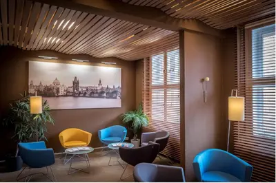 a waiting room with chairs and a painting on the wall at Pytloun Kampa Garden Hotel Prague in Prague