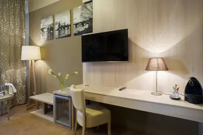 a room with a desk with a lamp and a chair at Pytloun Kampa Garden Hotel Prague in Prague