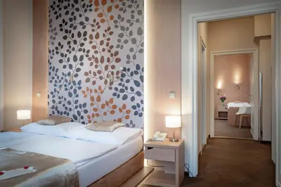 a bedroom with a bed and a wall with a pattern at Pytloun Kampa Garden Hotel Prague in Prague