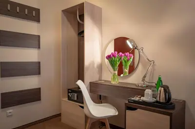 a room with a desk with a mirror and a white chair at Pytloun Kampa Garden Hotel Prague in Prague