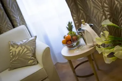 a table with a bowl of fruit and a chair at Pytloun Kampa Garden Hotel Prague in Prague