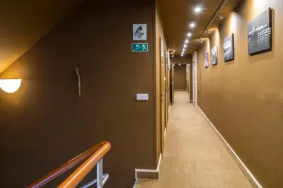a long hallway with stairs and signs on the wall at Pytloun Kampa Garden Hotel Prague in Prague