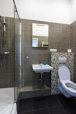 a bathroom with a toilet and a sink and a shower at SlaBur Residence in Prague