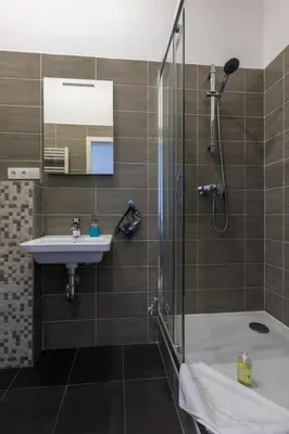 a bathroom with a shower and a sink and a tub at SlaBur Residence in Prague