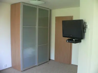 a glass cabinet with a television in a room at Penzion Speller in Vysoký Újezd