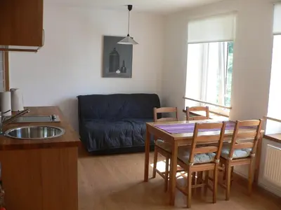 a kitchen and living room with a table and a couch at Penzion Speller in Vysoký Újezd