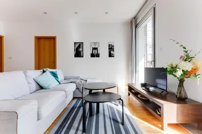 a living room with a white couch and a tv at Teichmann Premium Apartments in Prague