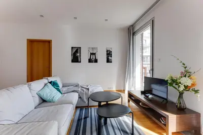 a white living room with a white couch and a tv at Teichmann Premium Apartments in Prague