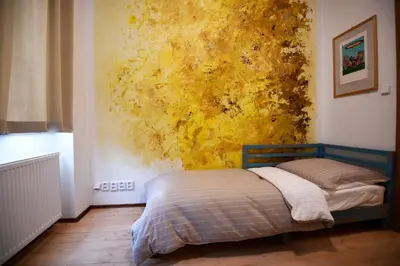 a bed in a bedroom with a yellow wall at Giotto Apartments in Prague