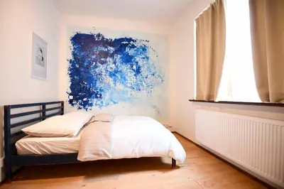 a bedroom with a bed with a blue painting on the wall at Giotto Apartments in Prague