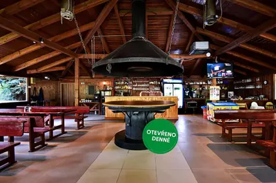 an empty restaurant with a large black pot hanging from the ceiling at Apartmány & Kemp Sázavský ostrov in Sázava