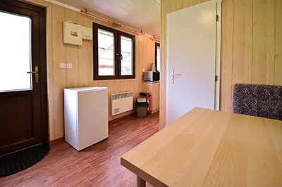 a kitchen with a table and a refrigerator in a room at Apartmány & Kemp Sázavský ostrov in Sázava