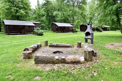 a garden with a stone stove in a field at Apartmány & Kemp Sázavský ostrov in Sázava