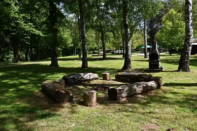 a group of logs and a monument in a park at Apartmány & Kemp Sázavský ostrov in Sázava