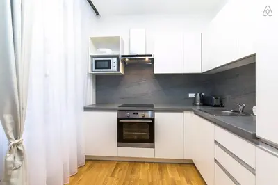 a kitchen with white cabinets and a sink and a microwave at Wishlist Prague Residences - Old Town Dlouha in Prague